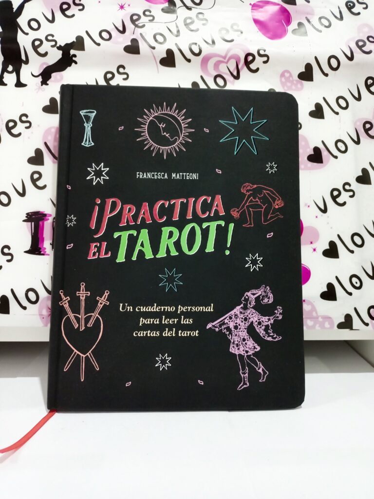 Un libro de tarot sobre una mesa con fondo decorativo de corazones
